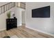 Bright room with wood-look flooring and decor elements, with view of staircase and adjacent hall at 17605 Ponderosa Ave, Parker, CO 80134