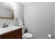 Half bathroom featuring wood vanity, white toilet, towel rack and rectangular mirror at 8979 Field St # 27, Westminster, CO 80021