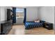 Cozy bedroom with a blue striped bed, wood floors, and black furnishings at 8979 Field St # 27, Westminster, CO 80021
