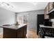 Bright modern kitchen featuring wood floors, an island, black appliances and sliding door at 8979 Field St # 27, Westminster, CO 80021