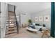Bright living room with stairs, a blue sofa, modern decor, and wood floors at 8979 Field St # 27, Westminster, CO 80021