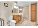 Well-lit bathroom featuring a modern vanity, toilet, and enclosed shower with detailed tile work at 811 Panorama Dr, Elizabeth, CO 80107