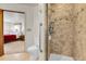 Tiled shower with glass door in bathroom, adjacent to the main bedroom, providing convenience and style at 811 Panorama Dr, Elizabeth, CO 80107