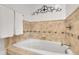 Elegant bathtub featuring tile surround, decorative accent and plush, white towels at 811 Panorama Dr, Elizabeth, CO 80107