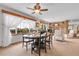 Open dining area with natural light, showcasing the wooden table, chairs, and stone fireplace in the living area at 811 Panorama Dr, Elizabeth, CO 80107