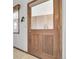 Rustic wooden front door with glass inset and vintage hardware adds charm to the inviting entryway at 811 Panorama Dr, Elizabeth, CO 80107