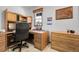 Cozy home office with built-in desk, storage cabinets, and natural light from the window at 811 Panorama Dr, Elizabeth, CO 80107