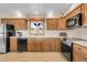 Traditional kitchen featuring wood cabinets, modern appliances, and a window with a view at 811 Panorama Dr, Elizabeth, CO 80107