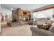 Comfortable living room featuring a stone fireplace, large windows with sheer curtains, and plush seating at 811 Panorama Dr, Elizabeth, CO 80107