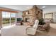 Bright living room featuring a stone fireplace, large windows, and comfortable seating, perfect for relaxing by the fire at 811 Panorama Dr, Elizabeth, CO 80107