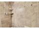 Elegant shower with neutral tiles, built-in shelving, and sleek fixtures exudes modern comfort at 811 Panorama Dr, Elizabeth, CO 80107