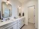 Well-lit bathroom featuring double sink vanity, modern lighting, and sleek countertop at 805 Promenade Dr, Superior, CO 80027