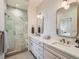 Bright bathroom featuring a double vanity, modern fixtures, and a luxurious walk-in shower with elegant marble tiling at 805 Promenade Dr, Superior, CO 80027