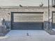 Attached garage with a modern door and stone accents at 805 Promenade Dr, Superior, CO 80027