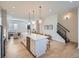 Open kitchen and living area with hardwood floors, a large island, and modern lighting fixtures at 805 Promenade Dr, Superior, CO 80027