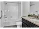 Clean bathroom with a shower-tub combo, granite countertop vanity, and white tile at 4569 Copeland Loop # 203, Highlands Ranch, CO 80126