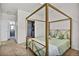 Inviting bedroom with view into closet, featuring a four-poster bed and light green bedding at 4569 Copeland Loop # 203, Highlands Ranch, CO 80126
