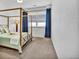 Bedroom showcasing a four-poster bed frame, light green bedding, and natural light through window blinds at 4569 Copeland Loop # 203, Highlands Ranch, CO 80126