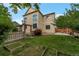 Large home backyard with a well-maintained lawn, garden beds, and a wooden pergola for outdoor enjoyment at 5571 S Sicily St, Aurora, CO 80015