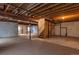 Unfinished basement featuring exposed beams and ductwork, offering ample potential for customization and expansion at 5571 S Sicily St, Aurora, CO 80015