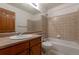 Cozy bathroom featuring a tub/shower combo, ample countertop space, and a classic wood-finished vanity at 5571 S Sicily St, Aurora, CO 80015