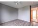 A quiet bedroom with wood-look floors, soft gray walls, and a ceiling fan for a comfortable and simple retreat at 5571 S Sicily St, Aurora, CO 80015