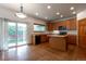 Well-lit kitchen with wood cabinets, center island, and a sliding door leading to the backyard at 5571 S Sicily St, Aurora, CO 80015