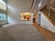 Open-concept living area featuring a staircase, wood floors, and connection to the kitchen at 5571 S Sicily St, Aurora, CO 80015