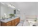 Bright bathroom featuring a soaking tub, double sinks, and modern lighting fixtures at 4320 Snowbird Ave, Broomfield, CO 80020