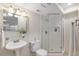 Bright bathroom featuring a glass-enclosed shower, pedestal sink, and modern fixtures at 4320 Snowbird Ave, Broomfield, CO 80020