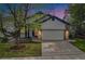 Charming home at twilight with a well-manicured lawn, concrete driveway, and inviting curb appeal at 4320 Snowbird Ave, Broomfield, CO 80020