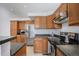 An updated kitchen with wood cabinets, black countertops, and stainless steel appliances at 4320 Snowbird Ave, Broomfield, CO 80020