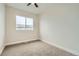 Carpeted bedroom with a ceiling fan and view to the community at 12032 Monaco St, Brighton, CO 80602