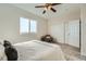 Carpeted bedroom with a ceiling fan, sliding closet doors, and a large window at 12032 Monaco St, Brighton, CO 80602