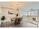 Modern dining area with stylish lighting, hardwood floors, and an open layout connecting to the living room at 12032 Monaco St, Brighton, CO 80602