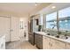 Well-lit kitchen features stainless appliances, white cabinets, and a view of the community at 12032 Monaco St, Brighton, CO 80602