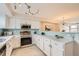 Bright kitchen with stainless steel appliances, white cabinetry, and an open layout to the dining area at 12032 Monaco St, Brighton, CO 80602