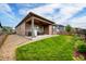 Beautiful backyard with a well-maintained lawn and covered patio, perfect for outdoor relaxation and entertainment at 5771 Slate River Pl, Brighton, CO 80601