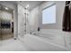Clean bathroom featuring a soaking tub with shower and window offering natural light at 5771 Slate River Pl, Brighton, CO 80601