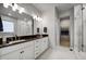 Modern bathroom with double vanity sinks, granite countertop, and a glass-enclosed shower at 5771 Slate River Pl, Brighton, CO 80601