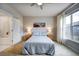 Comfortable bedroom with large window, ceiling fan, and ensuite bathroom entrance at 5771 Slate River Pl, Brighton, CO 80601