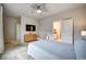 Bright bedroom with a ceiling fan, tv, crib and an adjacent bathroom at 5771 Slate River Pl, Brighton, CO 80601