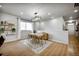 Contemporary dining area featuring a modern light fixture, sleek hardwood floors, and abundant natural light at 5771 Slate River Pl, Brighton, CO 80601