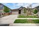 Charming single-Gathering home showcasing a landscaped front yard, stone accents, and a two-car garage at 5771 Slate River Pl, Brighton, CO 80601