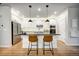 Beautiful kitchen island with dark granite countertops and white cabinets, complemented by modern pendant lighting at 5771 Slate River Pl, Brighton, CO 80601