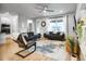 Bright living room featuring modern decor, area rug, and large window with neighborhood view at 5771 Slate River Pl, Brighton, CO 80601