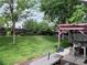 Large backyard with lush green lawn, mature trees, and outdoor dining area at 18908 E Napa Dr, Aurora, CO 80013