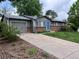 Single-story home featuring a gray exterior, brick accents, a blue front door, and a long driveway at 18908 E Napa Dr, Aurora, CO 80013
