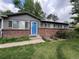 Front view of a home featuring gray siding, brick accents, a blue front door, and green landscaping at 18908 E Napa Dr, Aurora, CO 80013