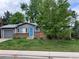 Charming single-story home with a blue front door, brick accents, and well-manicured lawn at 18908 E Napa Dr, Aurora, CO 80013